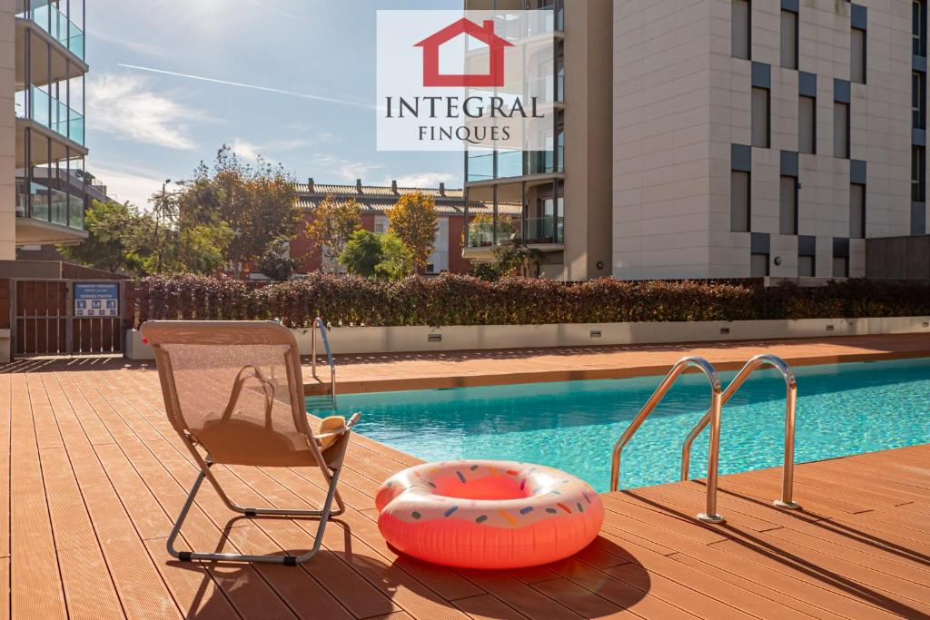 einen Stuhl und einen Stuhl neben einem Pool in der Unterkunft El Coralí Apartament Palamós in Palamós