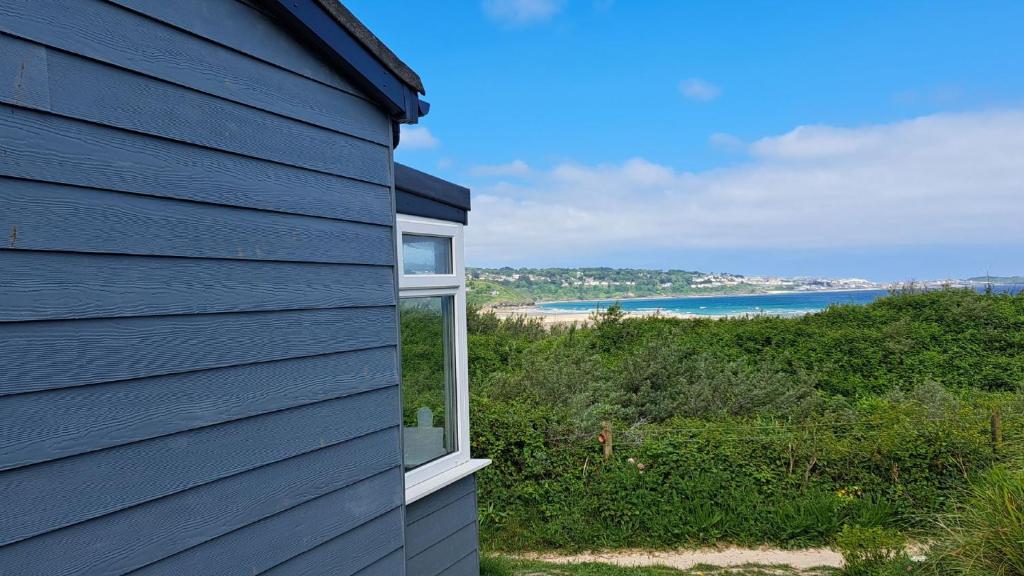 a blue house with a view of the beach at C15 Seamore, Riviere Towans in Hayle