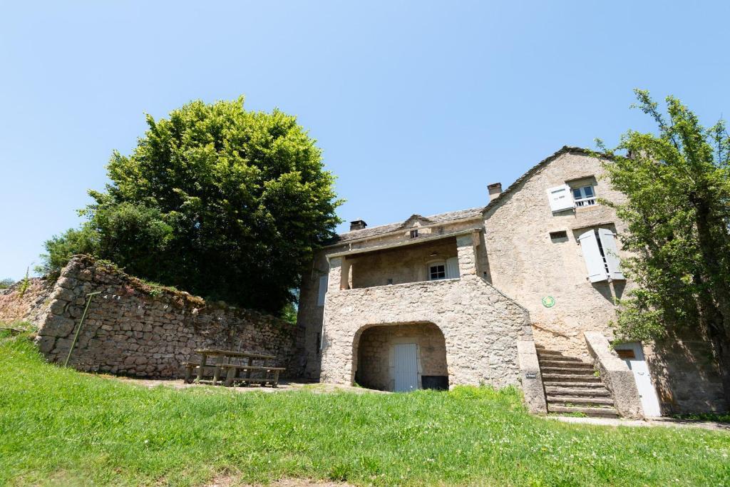 an old stone building on a grassy hill at Gîte Gîte Le Prieuré 5/6 personnes in Saint-Pierre-des-Tripiers