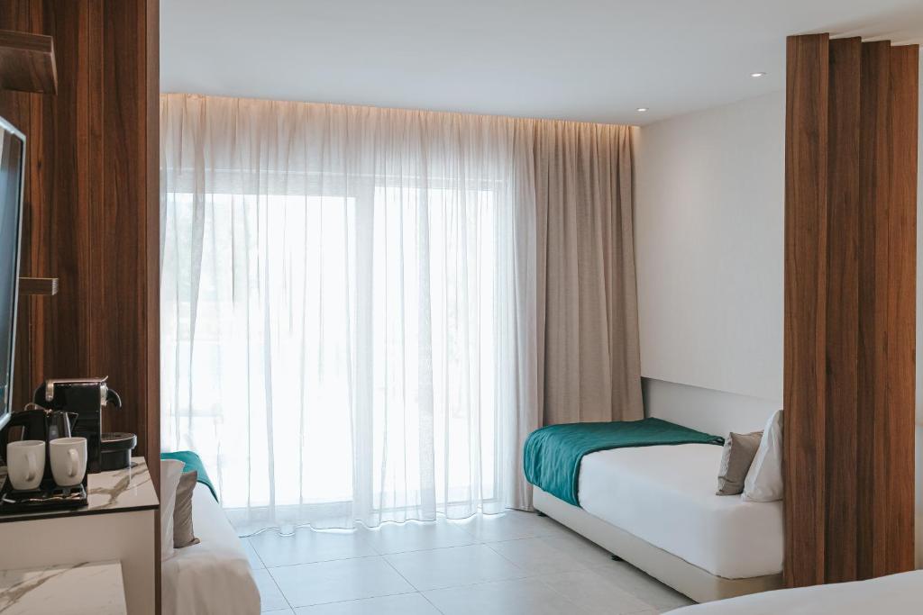 a hotel room with a bed and a large window at Atlantica Sungarden Park in Ayia Napa