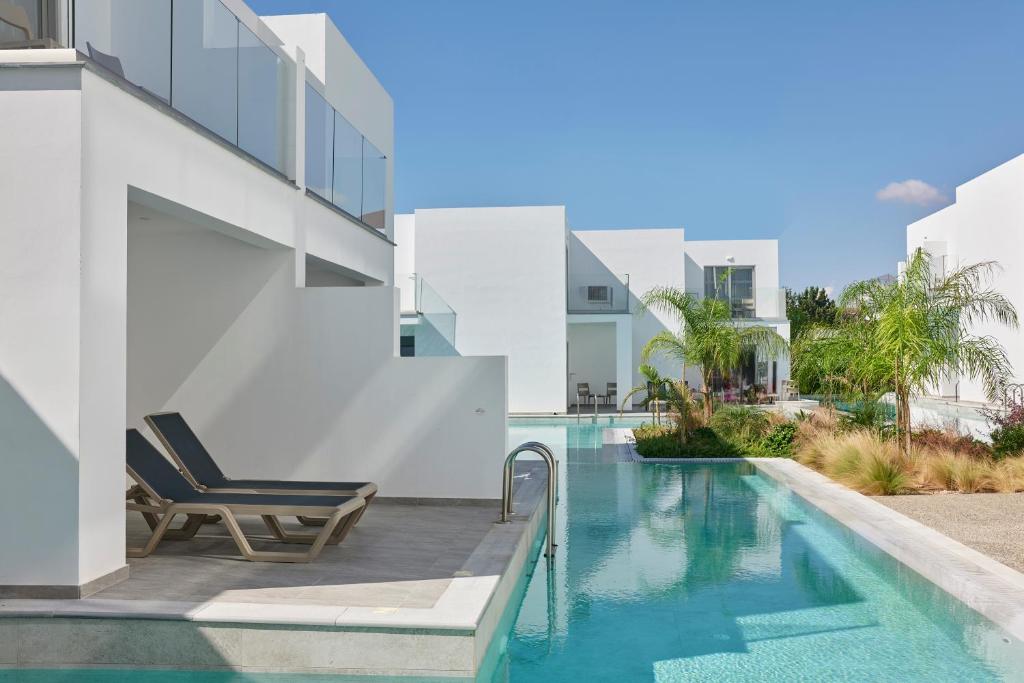 a swimming pool with a chair next to a building at Atlantica Sungarden Park in Ayia Napa