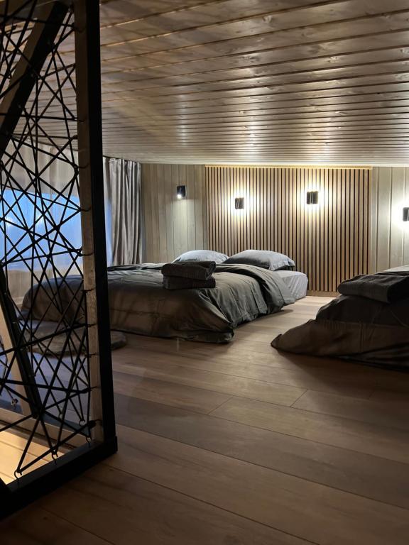 a bedroom with two beds and a large mirror at Villa Lakstīgalas Lux in Skrīveri