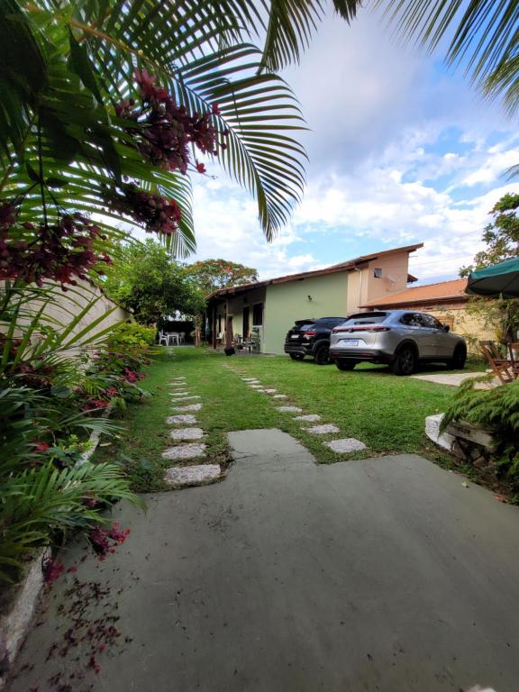 un vialetto con auto parcheggiate di fronte a una casa di Apartamento Perequê Lá da Ilha a Ilhabela