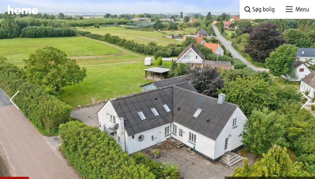 Luftaufnahme eines weißen Hauses mit schwarzem Dach in der Unterkunft Hestegården in Fåborg