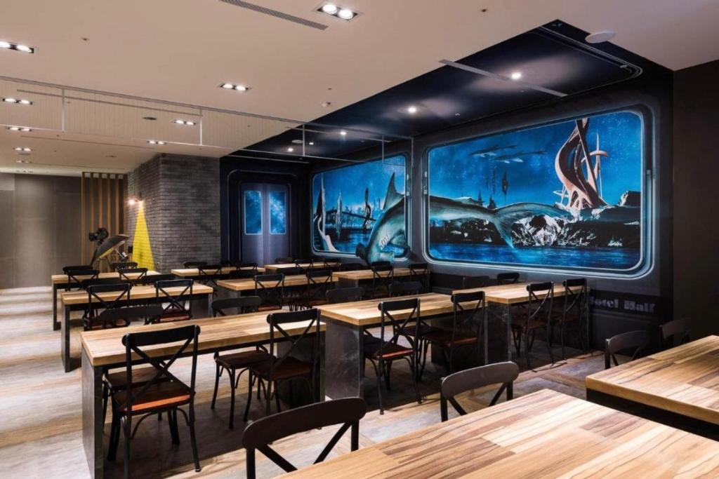 a restaurant with tables and chairs and large windows at 凝萃文旅 台中車站店 NCH-Business Hotel in Taichung