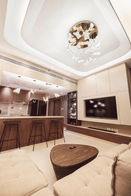 a living room with a couch and a table at Luxury Huge 1BR apartment With Private Garden in Uptown Al Zahia in Sharjah