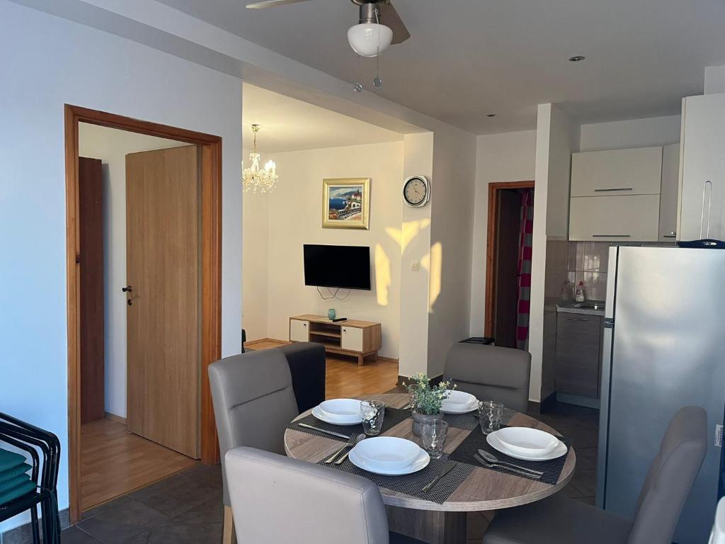 eine Küche und ein Esszimmer mit einem Tisch und Stühlen in der Unterkunft Apartments Sun Rogoznica in Podglavica