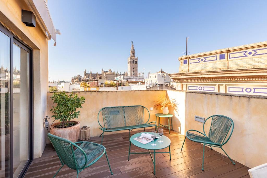 Hotel Duplex con Terraza Privada y vistas a la Catedral, a patio with chairs and a table on a balcony at Duplex con Terraza Privada y vistas a la Catedral in Seville