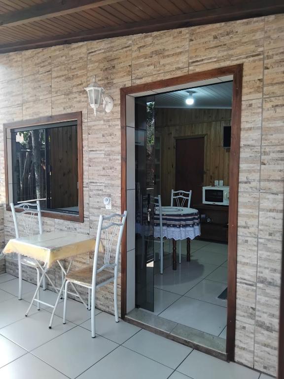 a glass door leading to a patio with a table and chairs at Studio dos Canyons in Praia Grande
