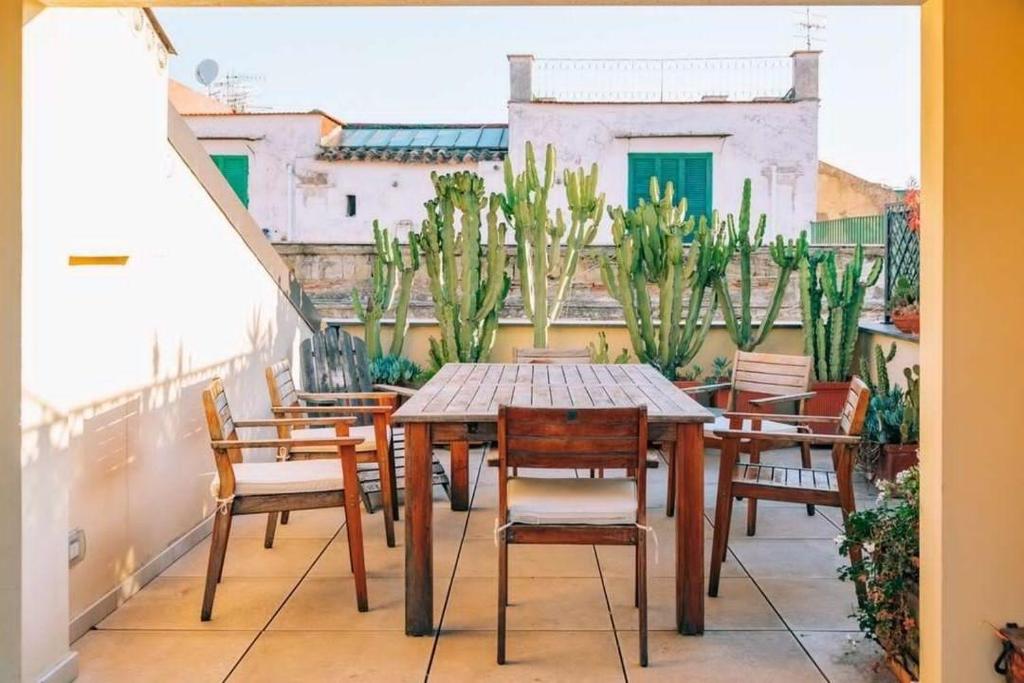 Un patio con una mesa y sillas en un balcón. en Magma Home - Rooms & Roof, en Nápoles