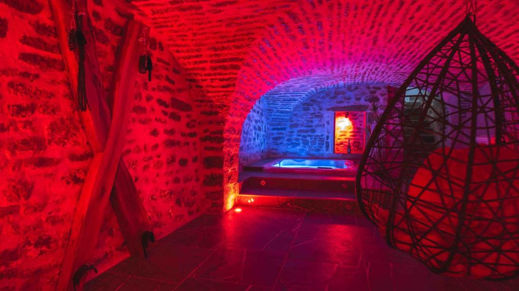 une chambre avec des lumières rouges et bleues et un tunnel dans l'établissement La reine dorel chambre romantique, à Besançon