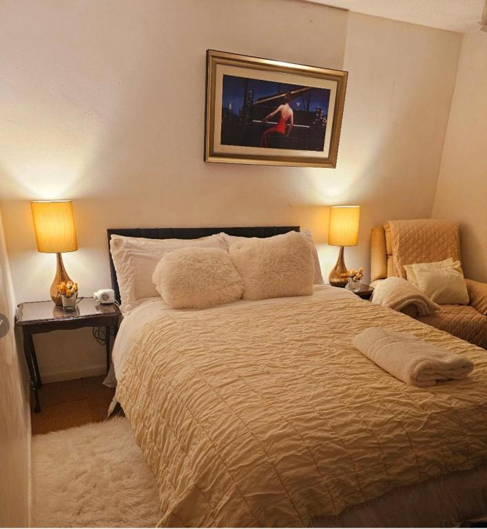 ein Schlafzimmer mit einem Bett, zwei Lampen und einem Stuhl in der Unterkunft Cuisinease in Ollerton