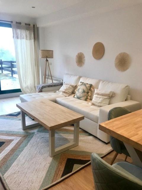 a living room with a white couch and a table at Lovely Duplex with Beatiful views in Panticosa in Panticosa