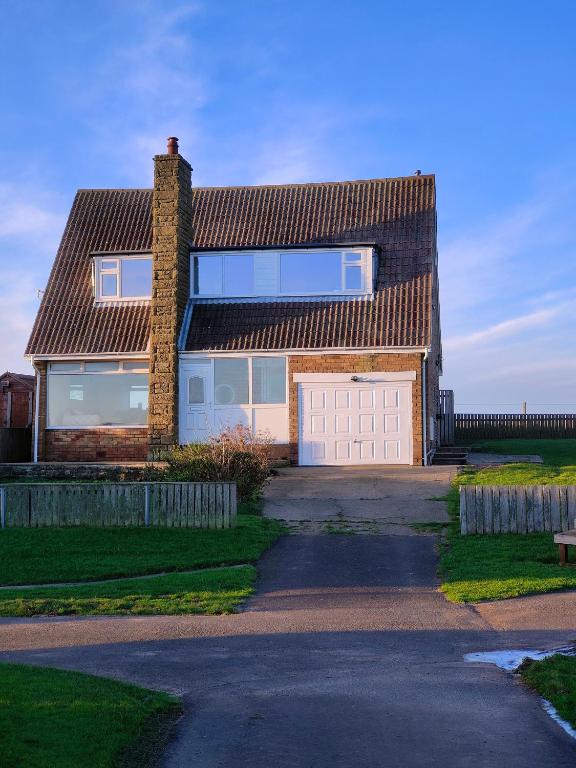 a brick house with a garage and a driveway at Hyecliffe House in Whitby