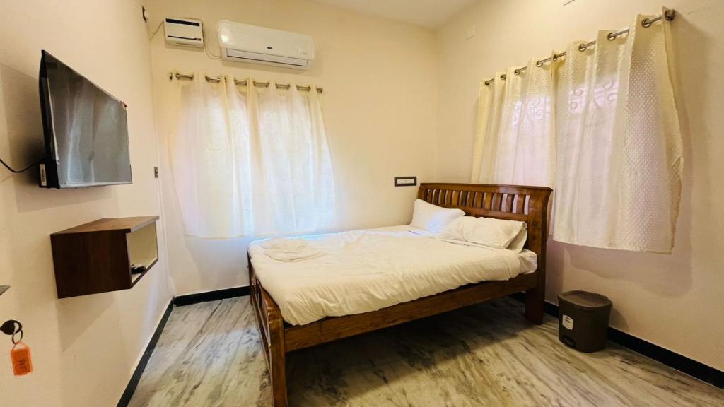 Cette petite chambre comprend un lit et une télévision. dans l'établissement Suya Stays, à Pondichéry