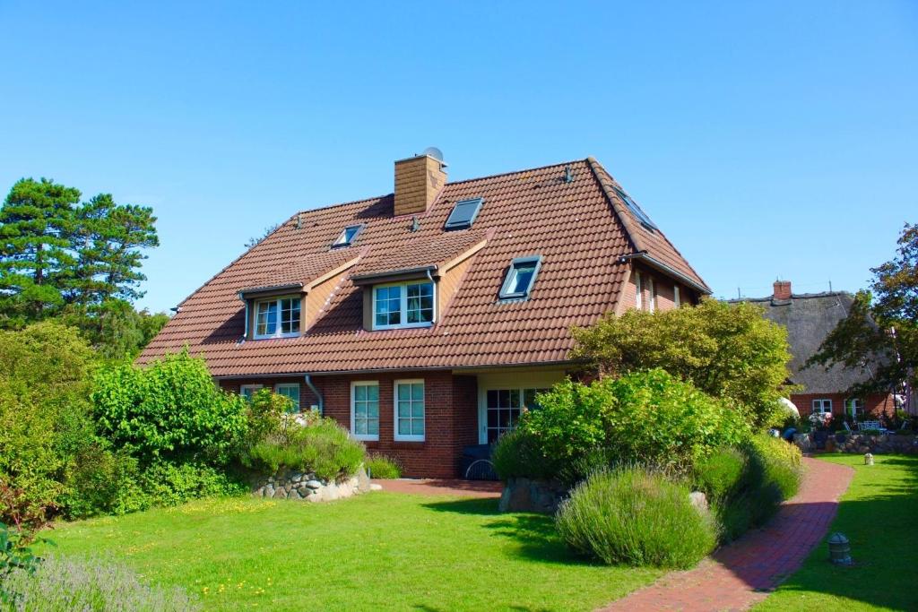 a house with a red roof on a green yard at Ginsterweg 1a in Wyk auf Föhr