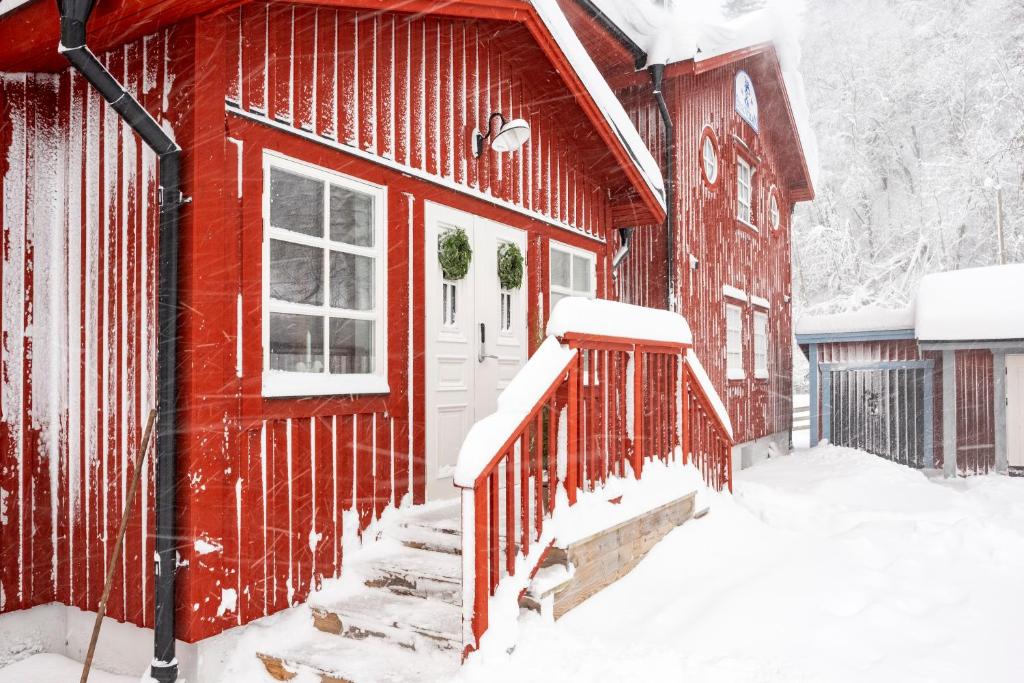 une maison rouge avec de la neige sur les marches dans l'établissement Bergvillan Ski Lodge, à Åre