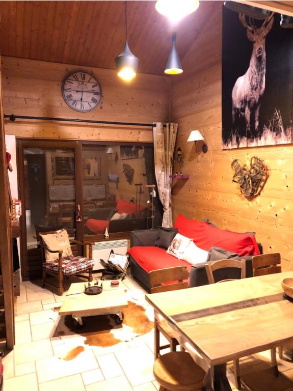 un salon avec un canapé et une horloge au mur dans l'établissement Annapurna LA CLUSAZ, à La Clusaz
