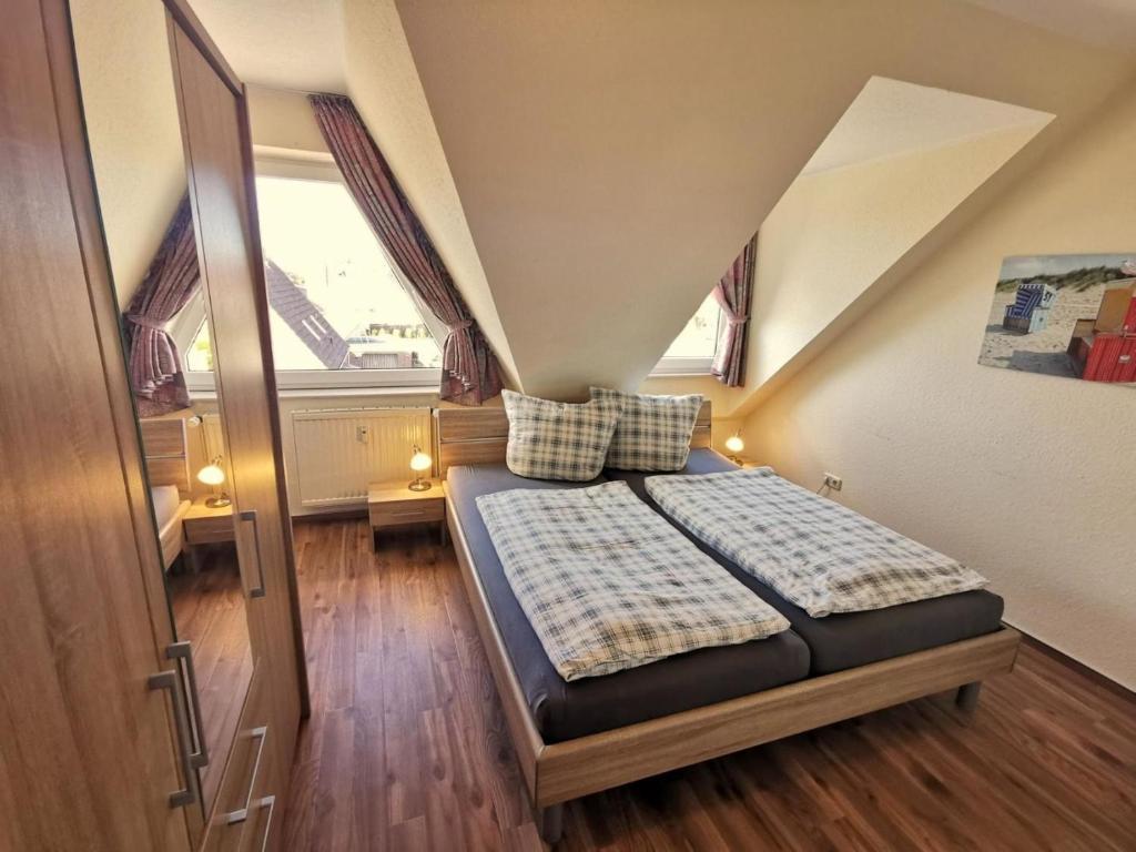 Dormitorio pequeño con cama en el ático en Wohnung 07, en Horumersiel