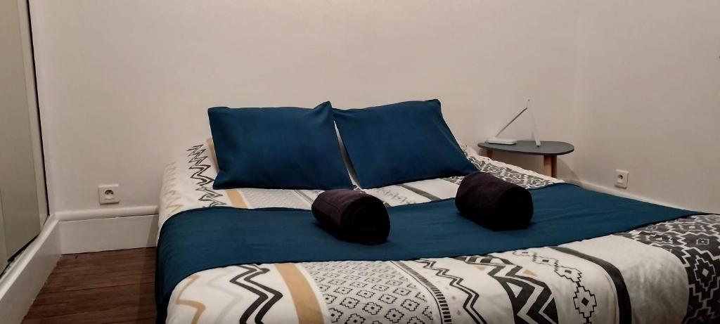 une chambre avec un grand lit avec des oreillers bleus dans l'établissement Le Bellevue de la Viotte, à Besançon