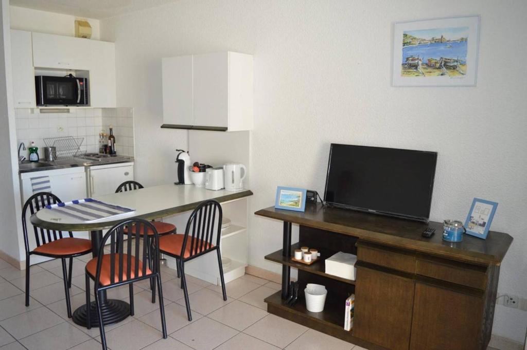 une cuisine avec une table et des chaises ainsi qu'une télévision dans l'établissement Appart Studio - cabine 4 couchages BANYULS SUR MER BN120-3204, à Banyuls-sur-Mer