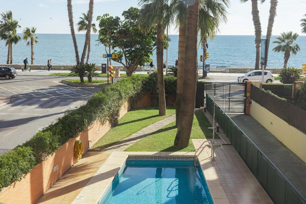ein Schwimmbad neben einer Straße und dem Meer in der Unterkunft Lemon Playa in Málaga