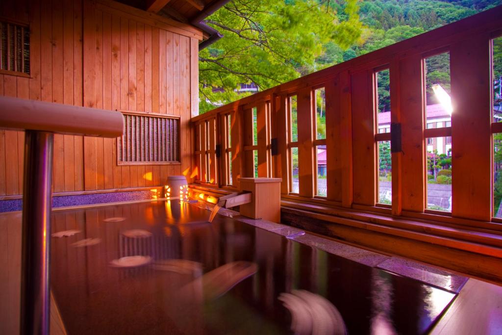 einen Pool in einem Holzgebäude mit Fenstern in der Unterkunft Onyado Tsutaya in Kiso