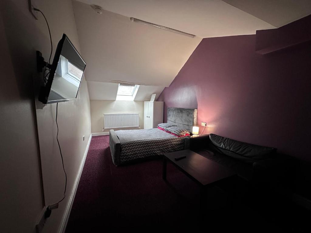 Una pequeña habitación con una cama y un televisor. en Best Apartments Mcr, en Mánchester