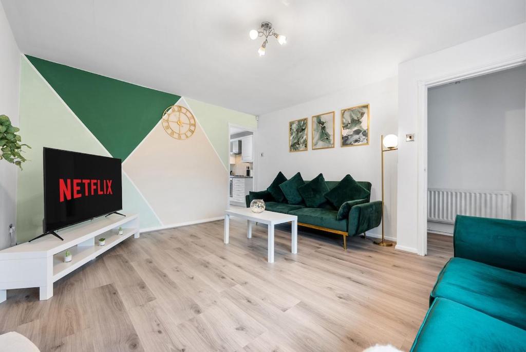 a living room with a green couch and a tv at Stylish 3 Bed House, Sleeps 6, Near NEC - Airport, Parking, Contractors - Families Stay in Sheldon