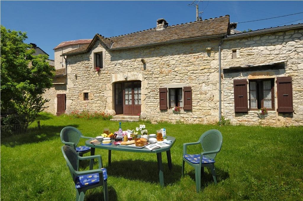 a table with food on it in front of a building at Gites de france 2 epis 5 personnes a mazel bouissy in Le Mazel-Bouissy