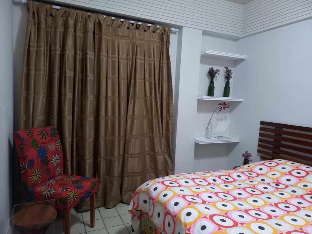 ein Schlafzimmer mit einem Bett und einem Stuhl und einem Fenster in der Unterkunft apartamento em aréa nobre in Vitória da Conquista