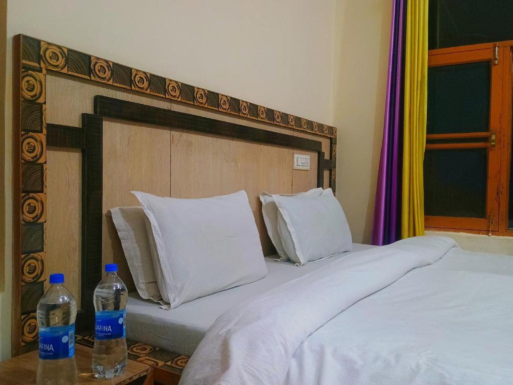 two bottles of water sitting on top of two beds at Verma Guest House in Dharmsala