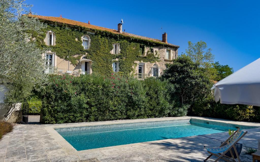 une maison avec piscine devant un immeuble dans l'établissement Maison du Lavoir Vert, à Tourbes