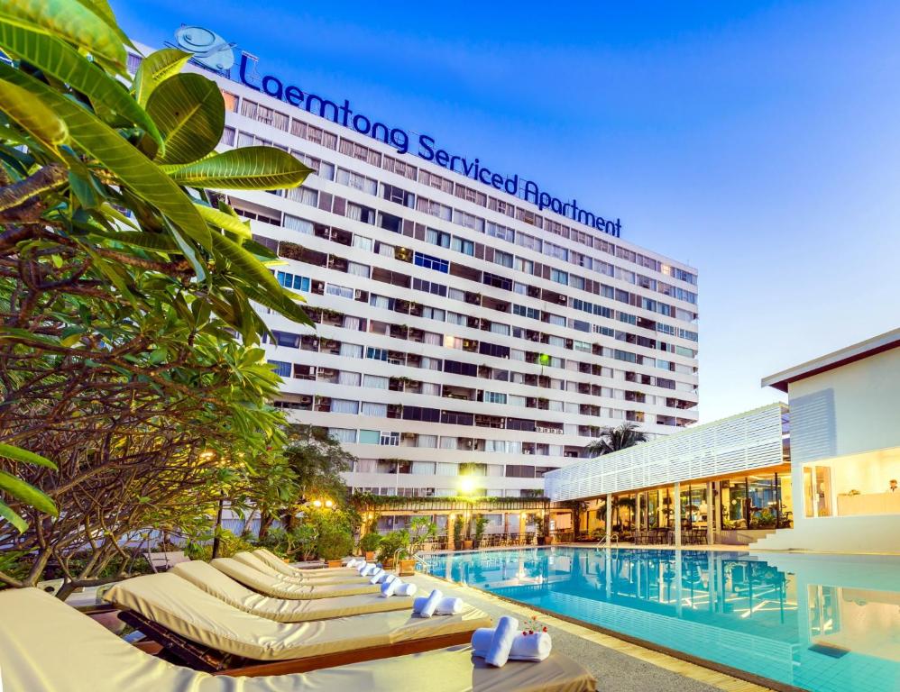 un hôtel avec des chaises longues et une piscine dans l'établissement Laemtong Serviced Apartment, à Si Racha