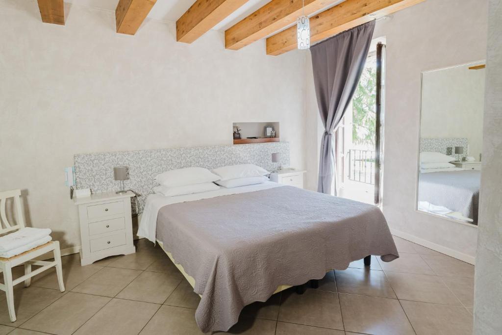 Un dormitorio blanco con una cama y una ventana. en Il Nido dei Gufi Bed and Breakfast, en Toscolano Maderno