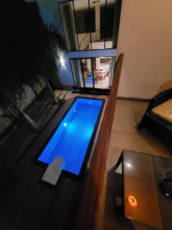 an overhead view of a swimming pool in a living room at Aurora-The Pool Villa in Kozhikode