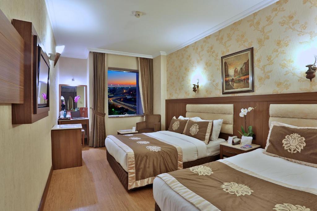 伊斯坦堡的住宿－希拉流姆大酒店，酒店客房设有两张床和窗户。