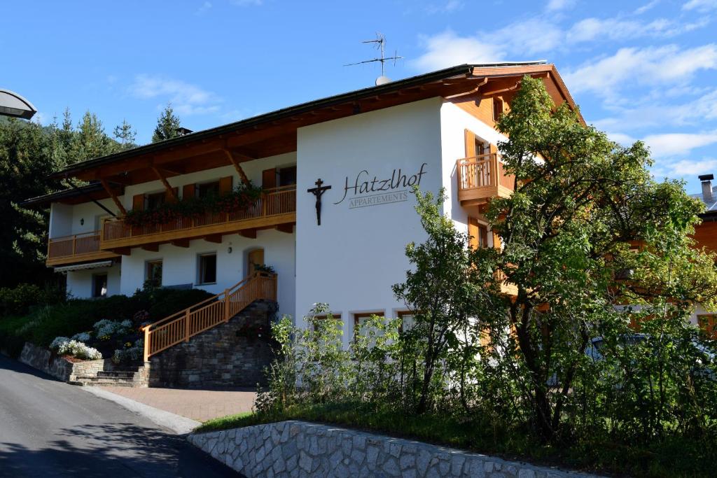 a building with a sign on the side of it at Appartaments Hatzlhof in Vipiteno