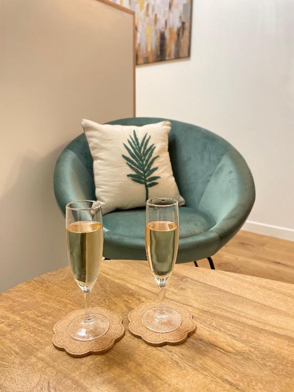 - deux verres de champagne sur une table en bois avec une chaise dans l'établissement Studio avec climatisation et parking, à Aix-en-Provence