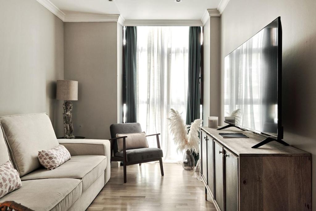 een woonkamer met een bank en een flatscreen-tv bij Apt 1B LuxuryRentalsMurcia in Murcia