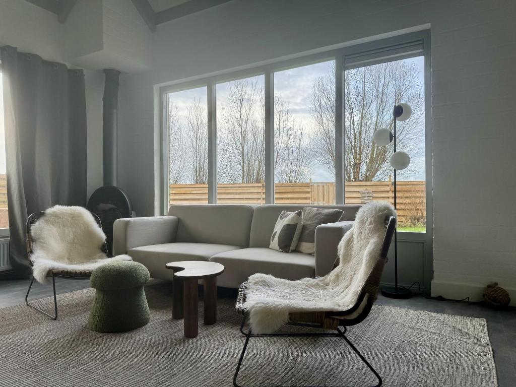 a living room with a couch and two chairs at Bungalowpark de Horn - 128 in Dirkshorn
