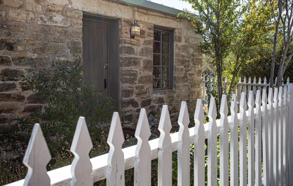 una cerca blanca frente a una casa en Charming 2BR Getaway Near Fredericksburgs Best Wineries, en Fredericksburg