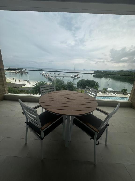 a table and chairs on a balcony with a view of the water at Apartamento Playa Escondida Marina & Resort in María Chiquita