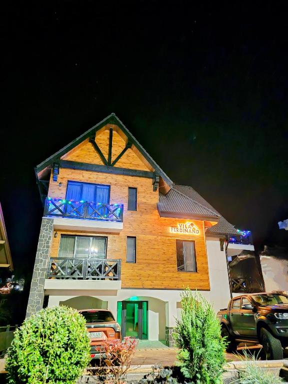a house with a car parked in front of it at Vila Ferdinand Apartments in Sinaia