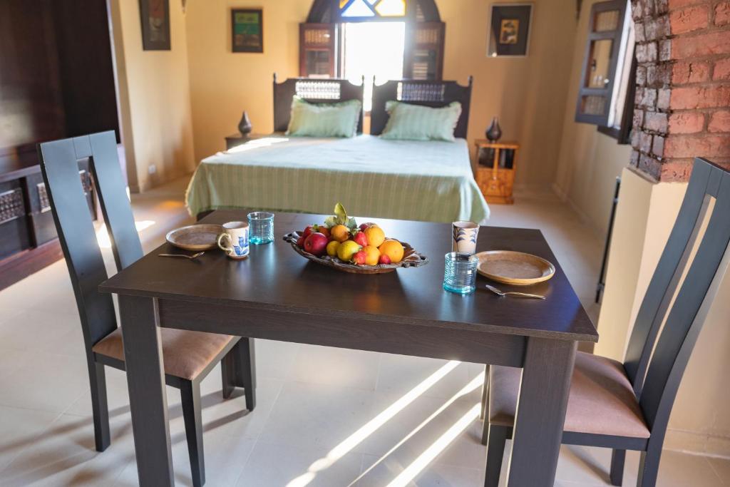 a bedroom with a table with a bowl of fruit on it at Laziza in Luxor