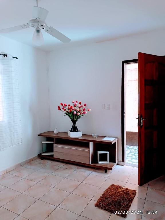 a room with a table with a vase of flowers on it at Casa do Anderson in Guarulhos