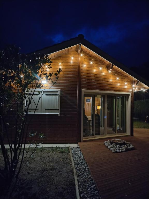 une maison avec des lumières sur son côté la nuit dans l'établissement Maison dans une bulle de verdure, à Lacanau