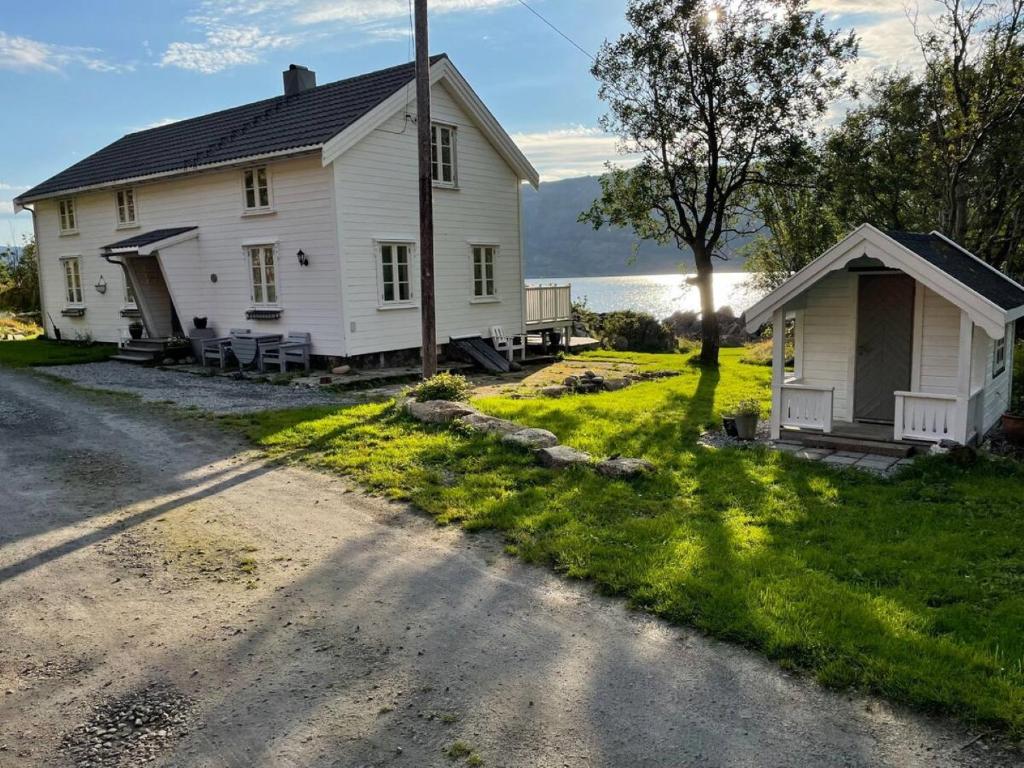 GravdalにあるVettingstua, beautiful house down by the sea.の道路脇の古い白屋