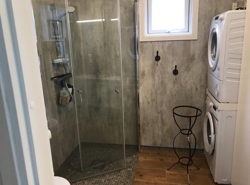 a shower with a glass door in a bathroom at Amazing waterfront rorbu (free car-charging) in Stamsund