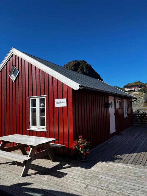 a red building with a picnic table in front of it at Rindebua in Stamsund
